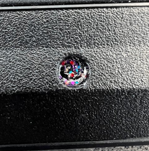 Photo of a screw covered with a unique pattern of (multi-color) glitter nail polish