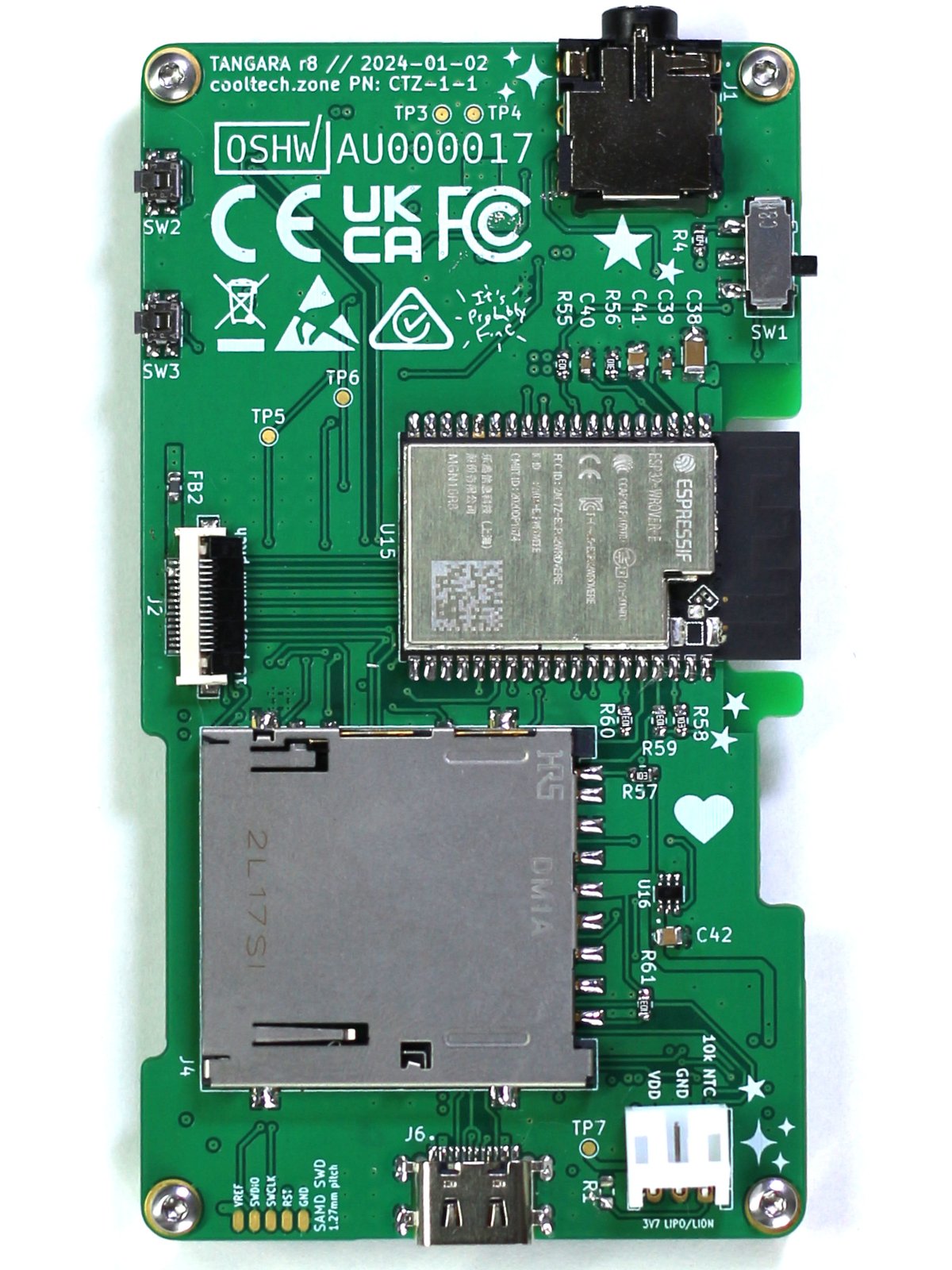 A rectangular, portrait-orientation PCB; it has a headphone jack, a switch, two small buttons, an ESP32 module, an SD card, a JST battery connector, and a USB-C port.