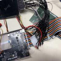 Ribbon cable connecting PicoIDE and enclosure, logic analyzer and probe wires, and prototype PicoIDE board