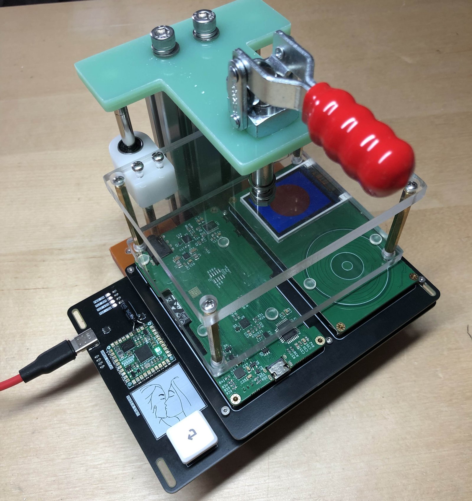 A pair of production boards in our testing jig. The little green light means the boards are good!