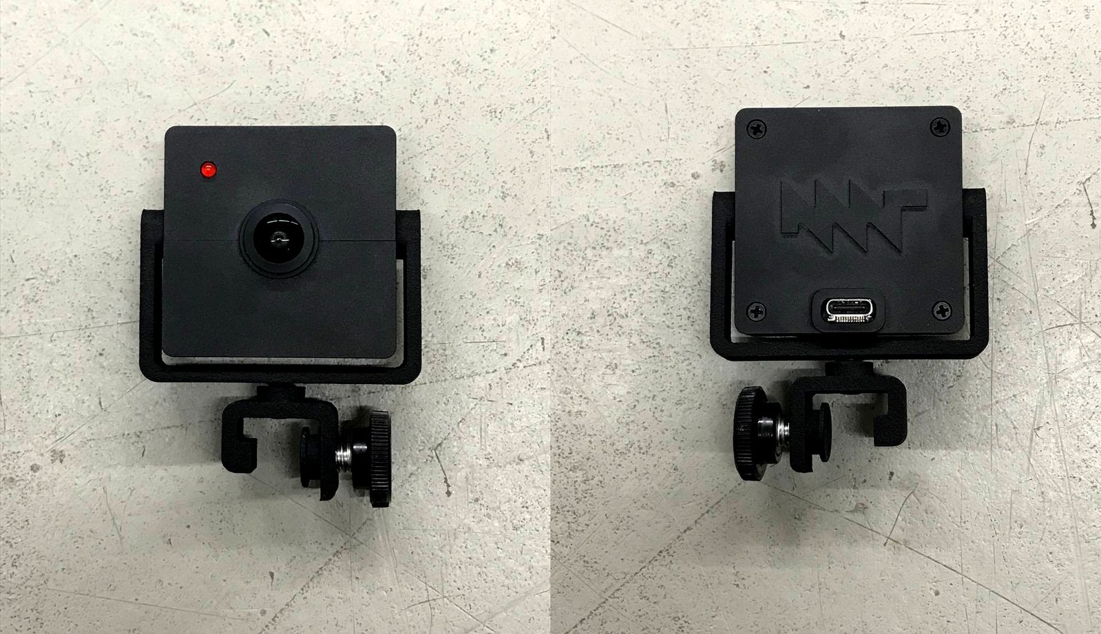 A front and rear view of the black, square MNT Reform camera, that has a lens and led on the front and the MNT logo and USB-C port on the rear
