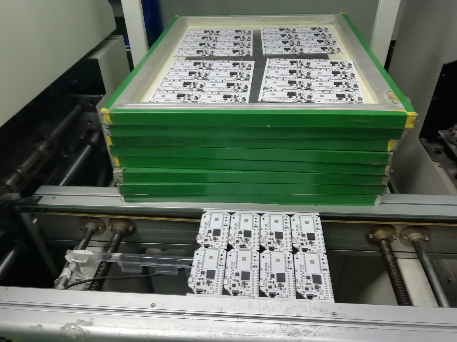 PCBs with solder paste applied and the larger components placed, waiting to go through the second round of pick and place