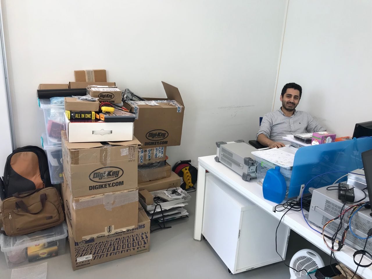 Adnan surrounded by Digikey boxes.